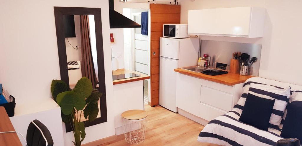 a small kitchen with a couch in a small apartment at Escapade Niortaise - Studios climatisés hyper-centre de Niort in Niort