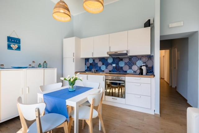 une cuisine avec une table bleue et des placards blancs dans l'établissement Mariviva Guest House, à Terracine