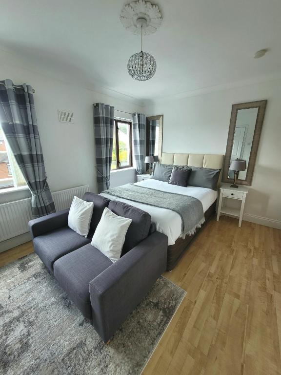 Un dormitorio con una cama grande y un sofá. en Grange House B&amp;B, en Galway