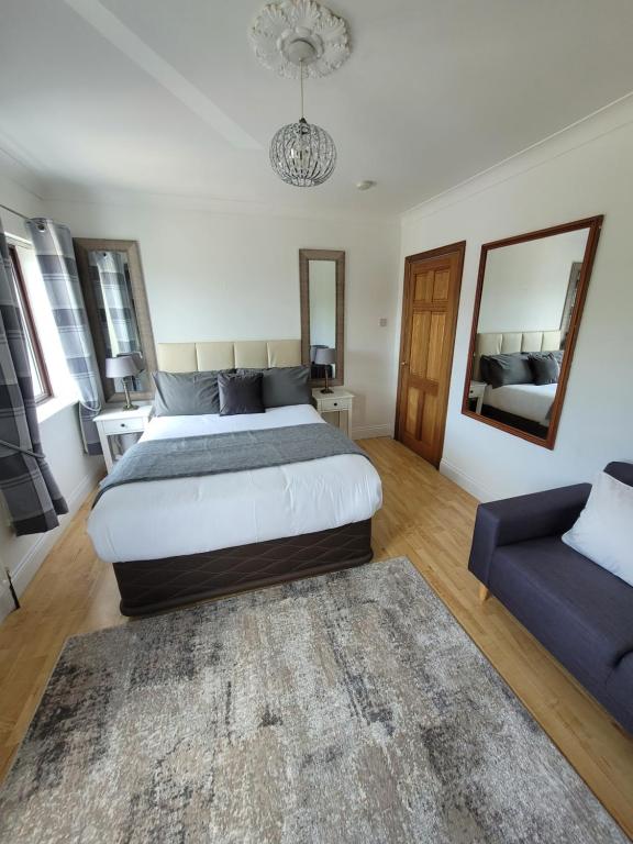 1 dormitorio con 1 cama grande y 1 sofá azul en Grange House B&B, en Galway