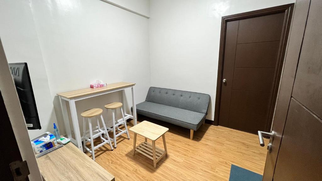 Cette petite chambre comprend une chaise bleue et une table. dans l'établissement Jannah’pad, à Manille