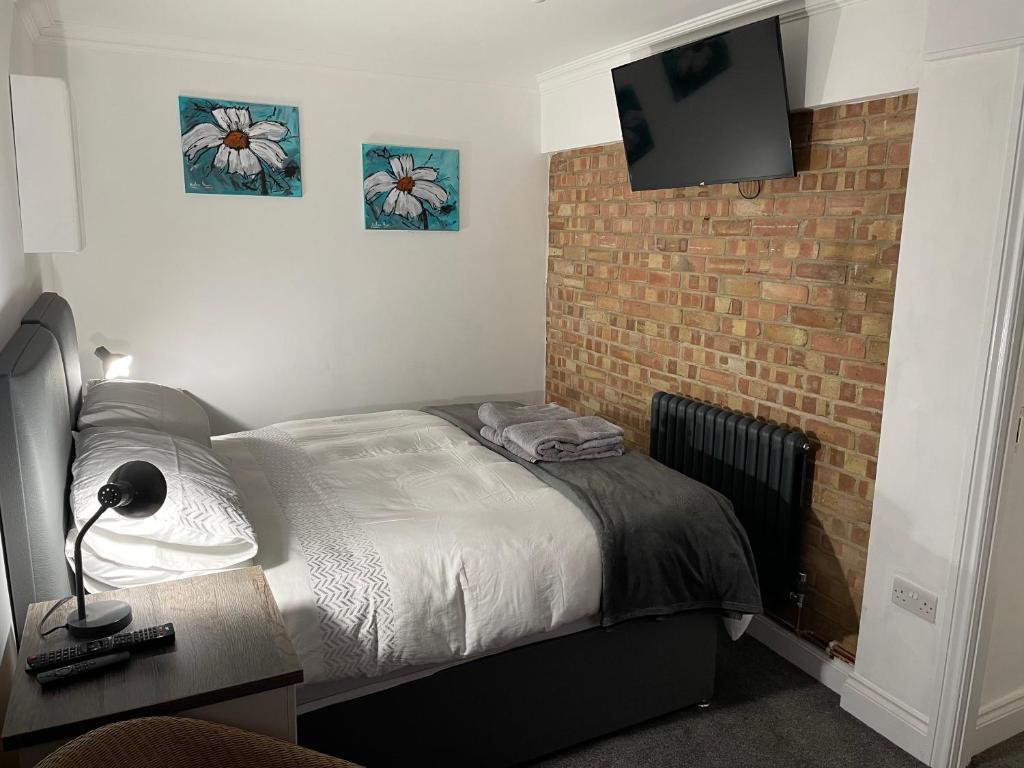 a bedroom with a bed and a brick wall at 31 Elwyn Snug in March