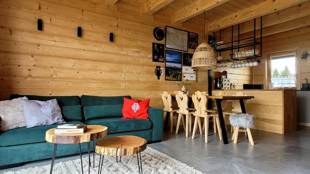 ein Wohnzimmer mit einem grünen Sofa und einem Tisch in der Unterkunft Domek na Kleninie z gorącą balią in Kamienica
