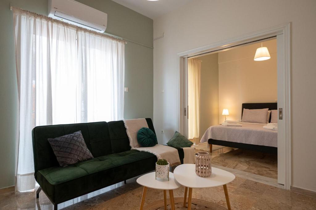 a living room with a green couch and a bed at Anesis with a Yard in Kalamata