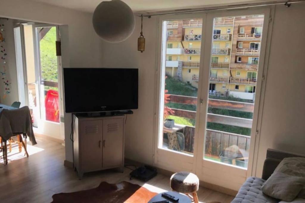 salon z telewizorem i dużym oknem w obiekcie Appartement charmant - Allos w mieście Allos