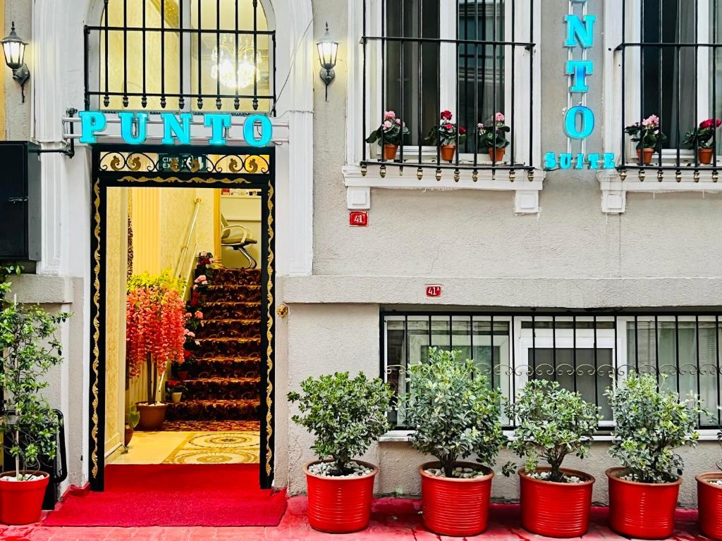 una entrada a un hotel con una alfombra roja y plantas en Punto Suite en Estambul