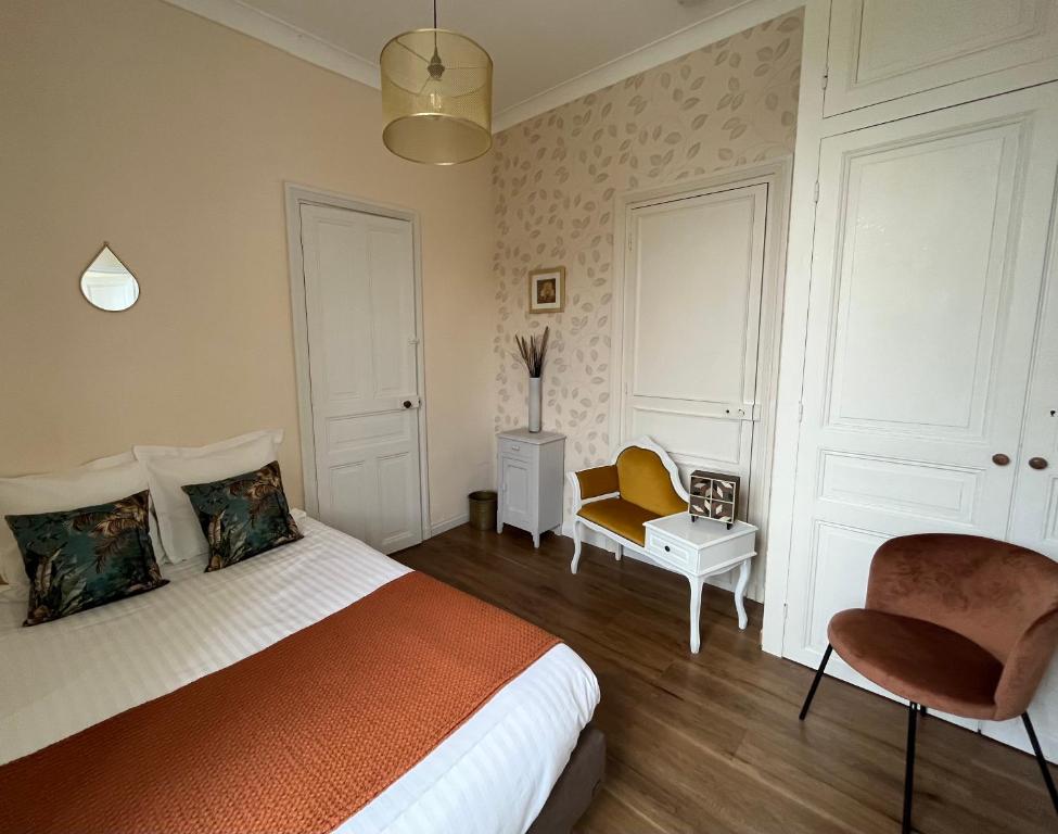 a bedroom with a bed and a chair in it at La Maison de Louisette in Le Faouët