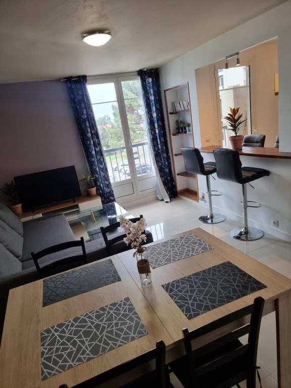 sala de estar con mesa de madera y sillas en Appartement VUe MER avec parking gratuit sur place, en Bastia