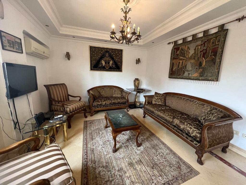 sala de estar con 2 sofás y TV en Shata Apartment - Families Only, en El Cairo