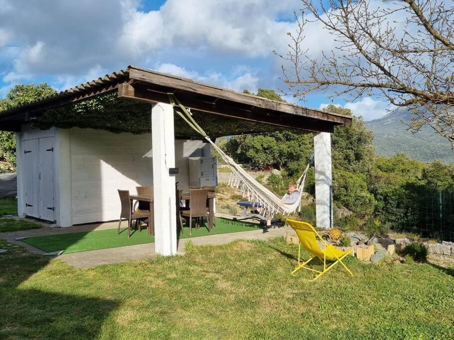 un homme dans une cour arrière avec un belvédère dans l'établissement appartement en rez de jardin, à Foce