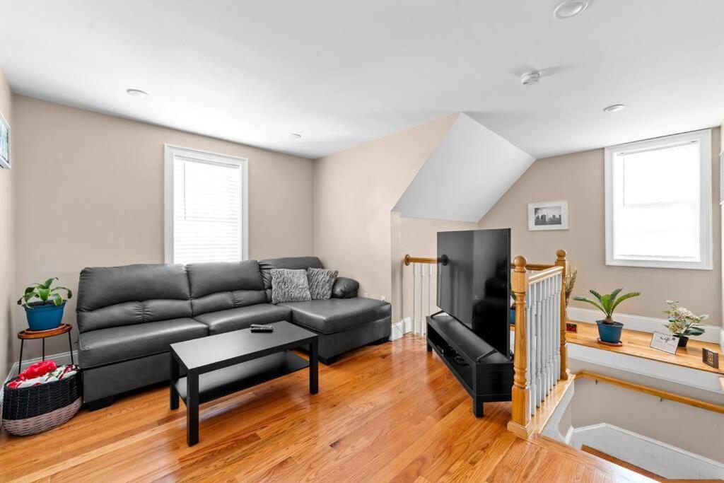 a living room with a black couch and a table at 555-2 6BR Quincy - Spacious Apt near Perry Beach in Quincy
