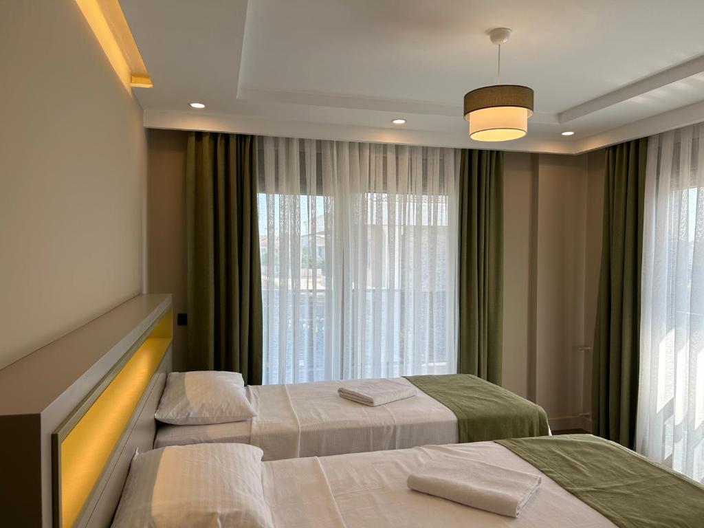 a hotel room with two beds and a window at Nirvana Belek Villas in Belek