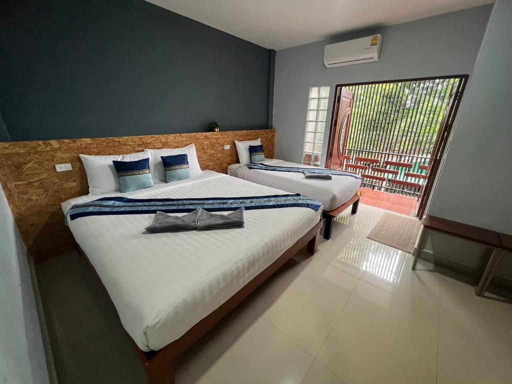 1 dormitorio con 2 camas y ventana con vistas en The Sekret Hotel, en Sungai Kolok