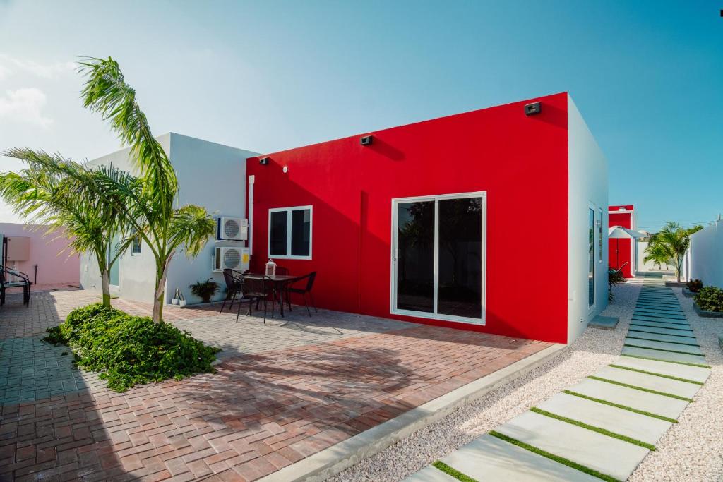 a red house with a palm tree in front of it at Trankilidad Apartments in Santa Cruz