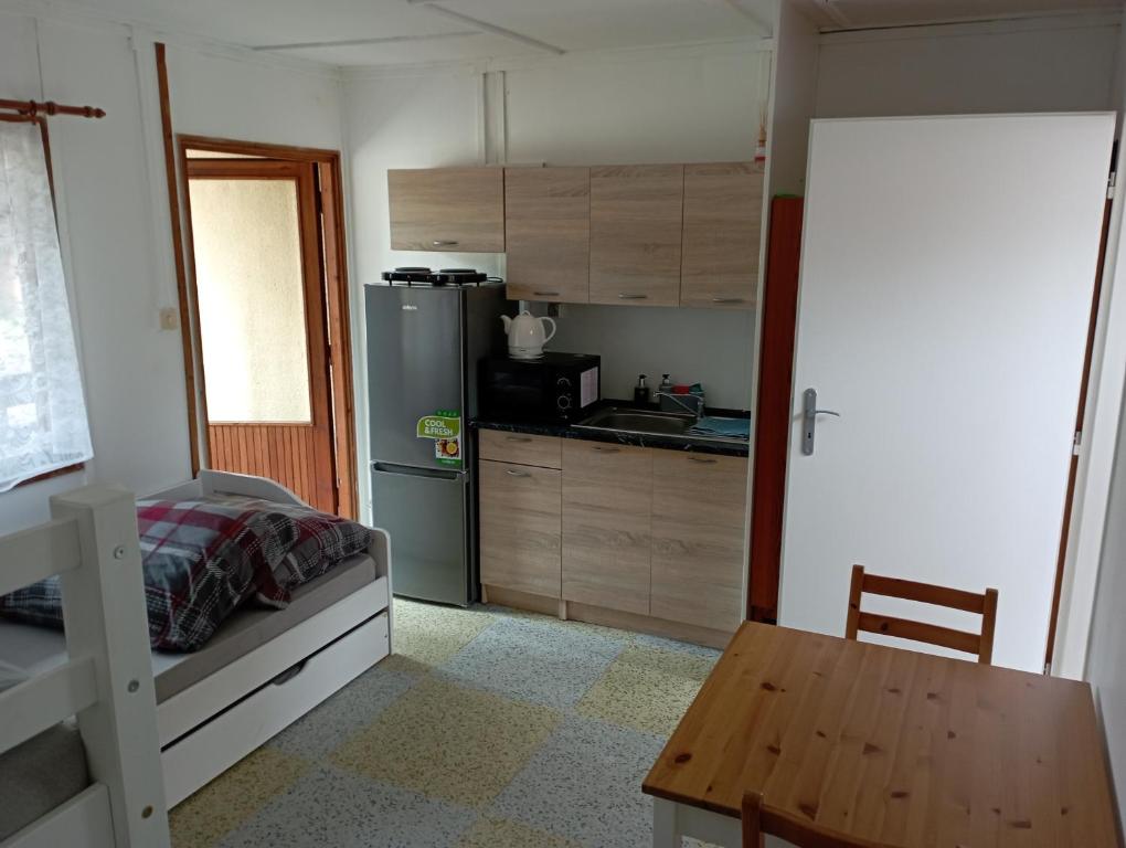 een keuken met een bed en een tafel in een kamer bij Chatka Andělka in Doksy