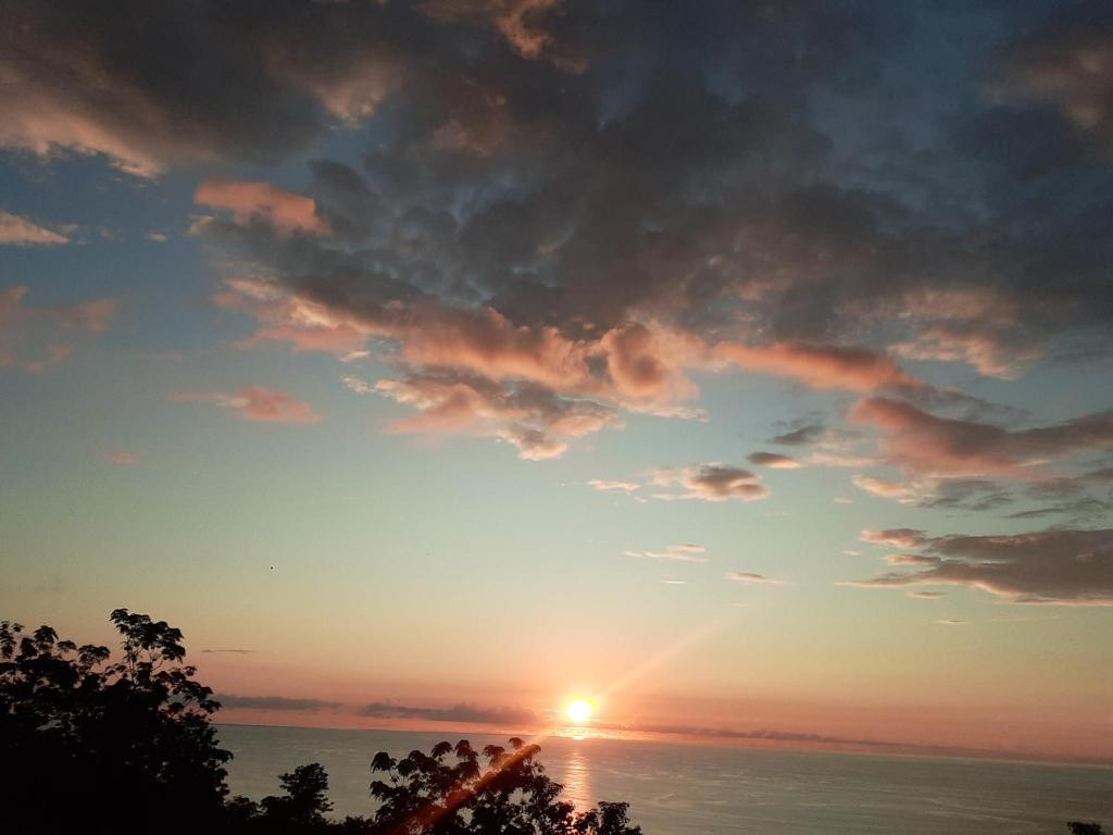 a sunset over the ocean with the sun in the sky at Leu Océans in Saint-Leu
