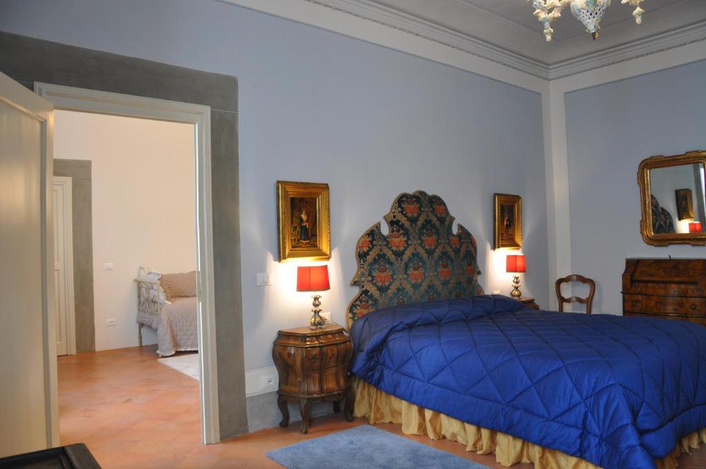 a bedroom with a bed with a blue comforter and two lamps at Le sale di Mozart in Florence