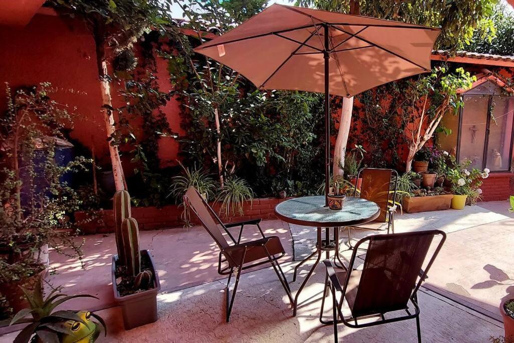 a table and chairs and an umbrella on a patio at Casa Rosa in Tepotzotlán