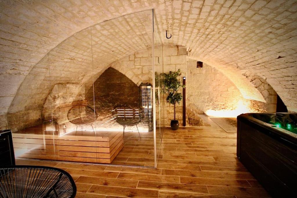 a room with a glass door in a stone wall at Spa Gaalor***** - Jacuzzi & Sauna à Rouen in Rouen