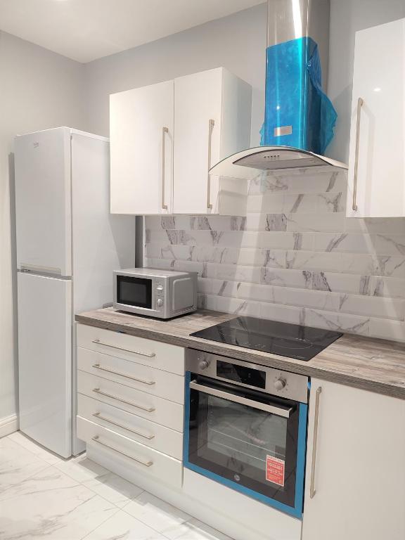 a kitchen with a stove top oven and a microwave at havilahomes in Manchester