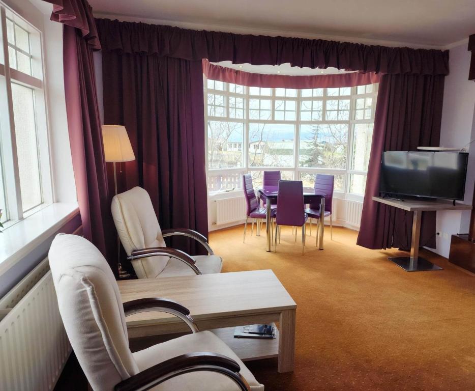 ブリョンドゥオースにあるKiljan Apartments & Roomsのリビングルーム(テーブル、椅子、テレビ付)