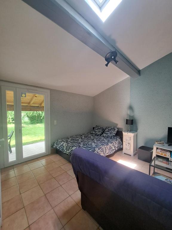 - une chambre avec un lit et une chambre avec une fenêtre dans l'établissement Studio avec jardin à 5 min du Parc Walibi, à Roquefort