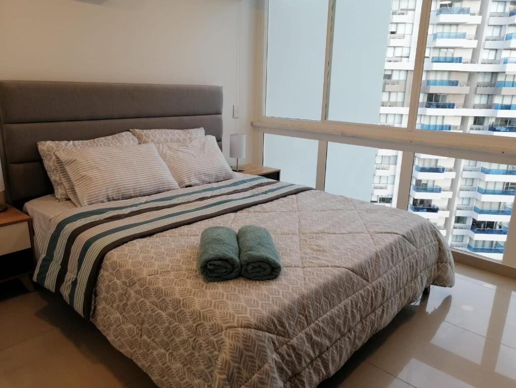 a bedroom with a bed with two towels on it at Apartamento cerca al mar, terraza con vista 360 in Santa Marta