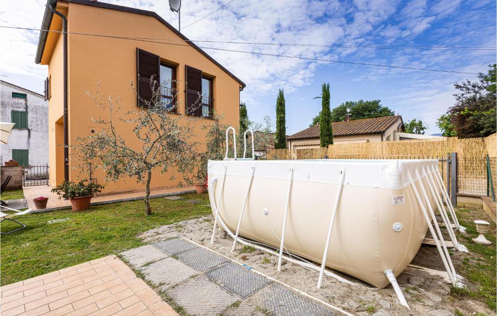 una gran bañera blanca sentada en un patio junto a una casa en Awesome Home In Orentano With Kitchen, en Orentano