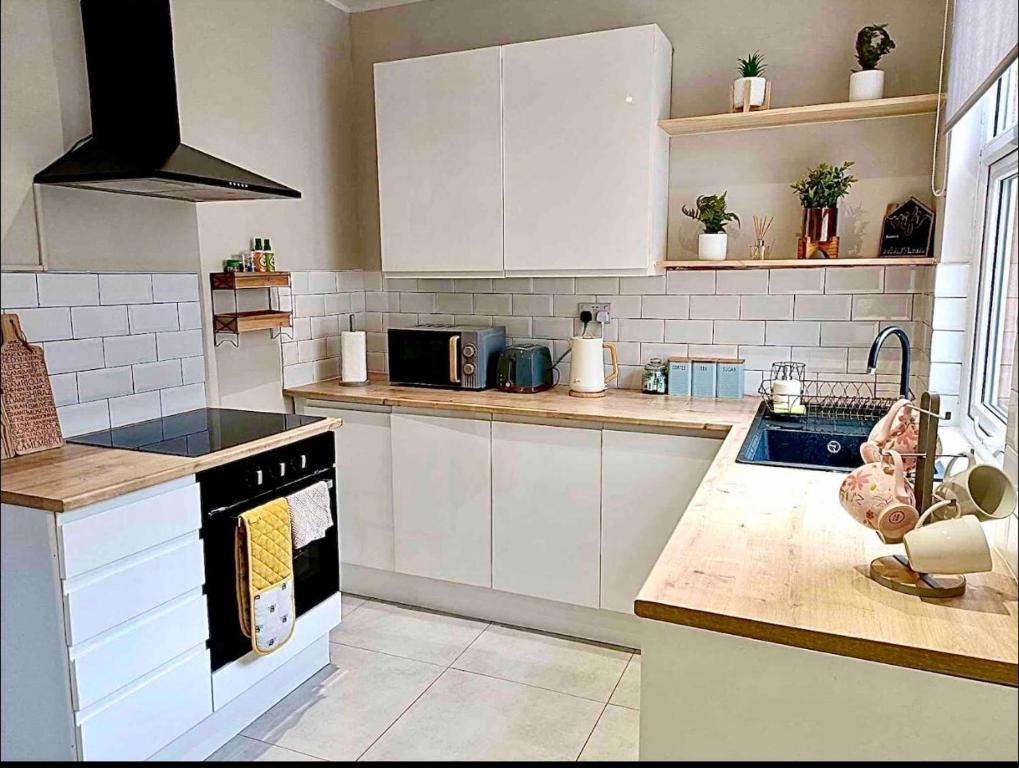 a kitchen with white cabinets and a stove top oven at Rosa House in Darlington