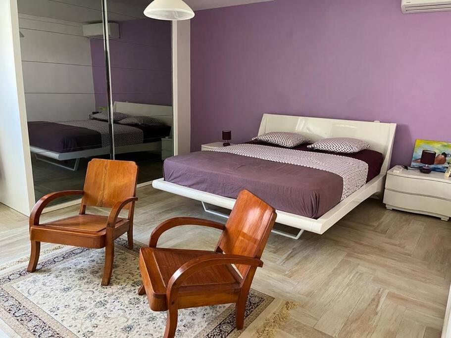 une chambre avec un lit et deux chaises dans l'établissement Villa Liliana, à Sainte-Rose