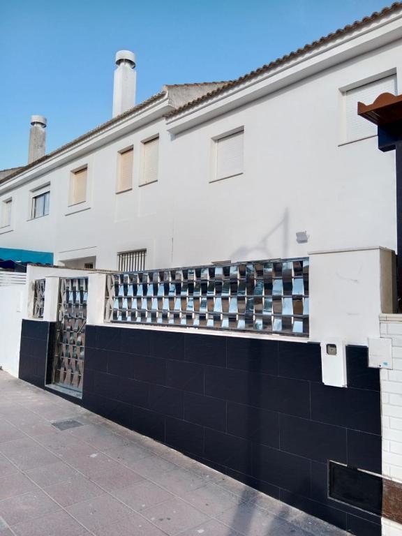 a white building with a black and white fence at Siorica Beach in Matalascañas