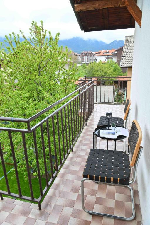 a patio with tables and chairs on a balcony at Discovery Apartment Bansko in Bansko