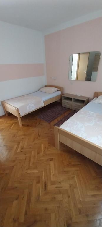 Duas camas num quarto com piso em madeira em Kuća za odmor Varoš em Vrlika