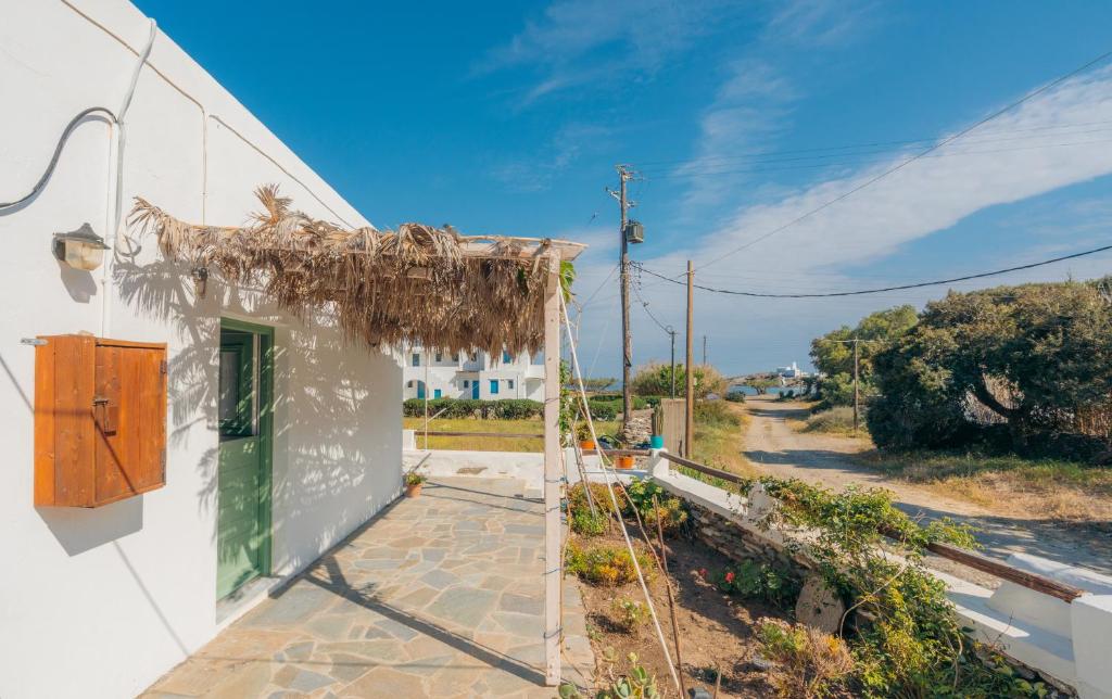 a white building with a green door and a street at Houses at Chrisopigi Sifnos in Chrisopigi