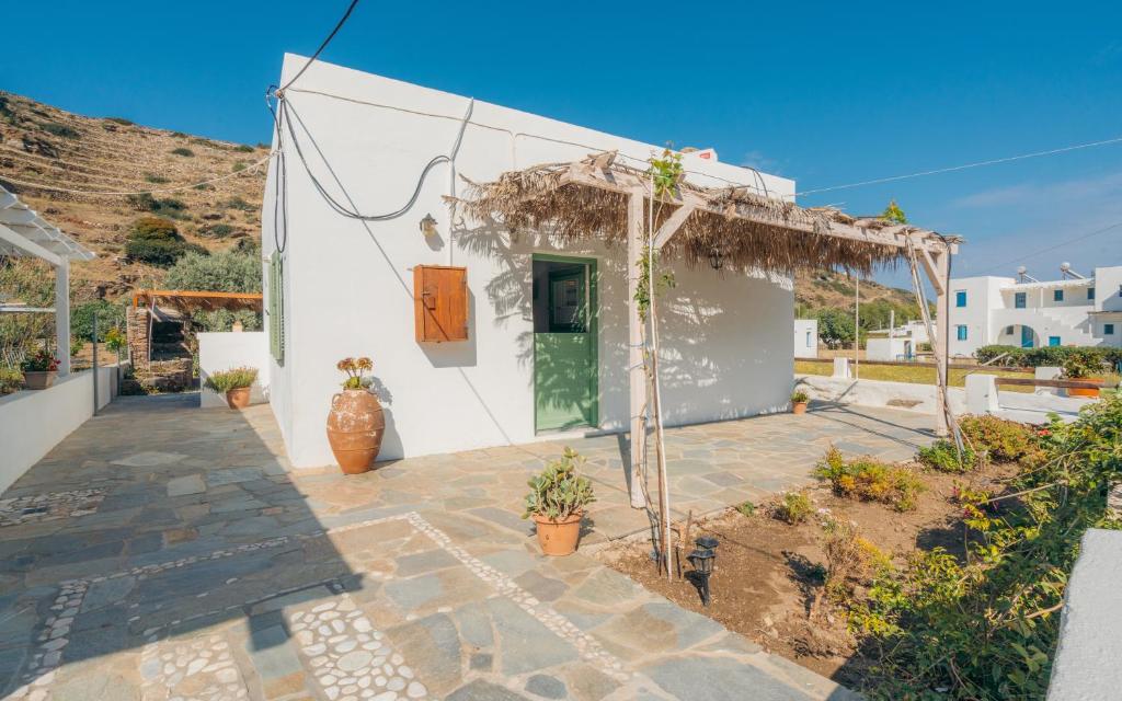 a white house with a green door on a hill at Houses at Chrisopigi Sifnos in Chrisopigi
