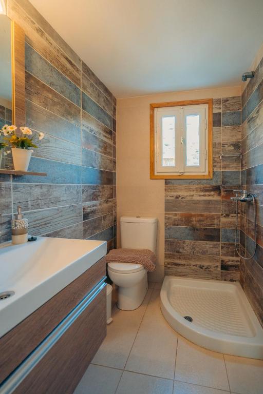 a bathroom with a toilet and a sink and a tub at Houses at Chrisopigi Sifnos in Chrisopigi