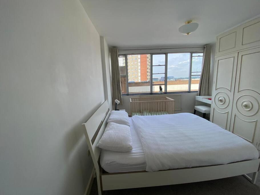 a bedroom with a white bed and a window at Sentinel 2 Bed Apartment in NW London in London