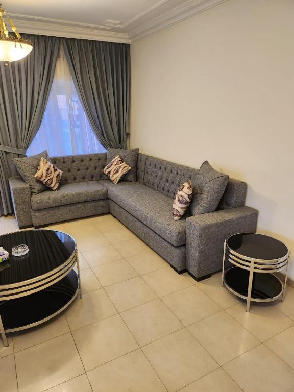 ein Wohnzimmer mit einem Sofa und 2 Tischen in der Unterkunft Rana's apartment in Amman