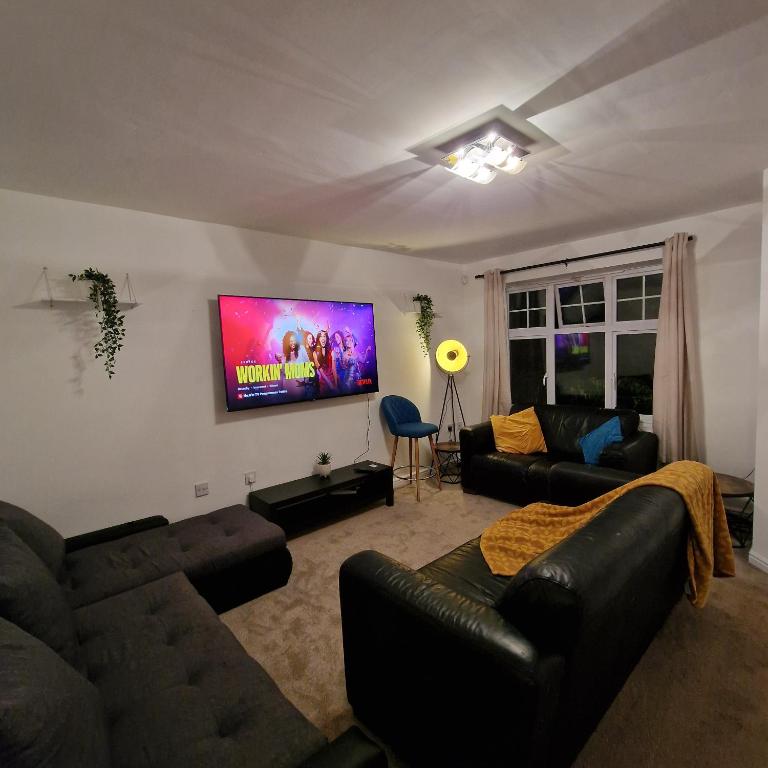 ein Wohnzimmer mit einem Sofa und einem Flachbild-TV in der Unterkunft Pet Friendly 3 Bedroom Apartment in Manchester by Sublime Stays in Manchester