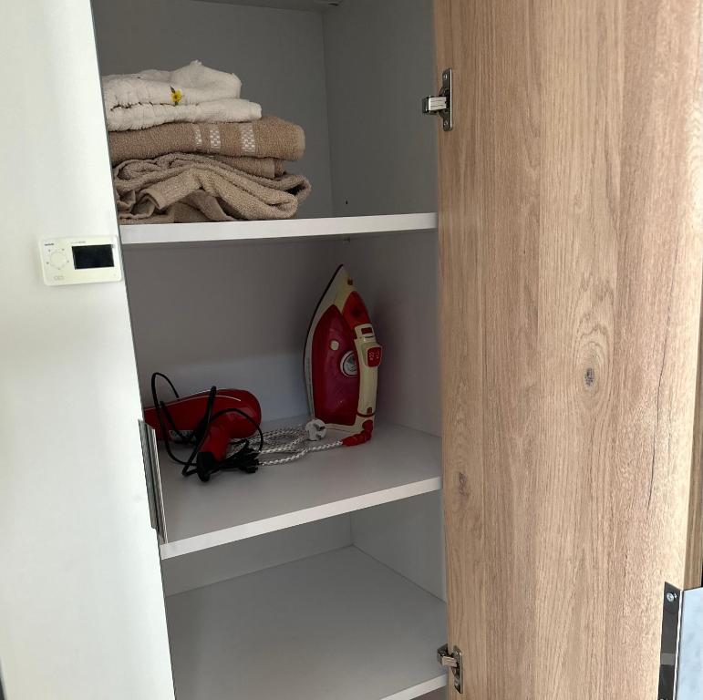 a closet with a fire extinguisher and some towels at Super cool apartment with pools and gym in Antalya