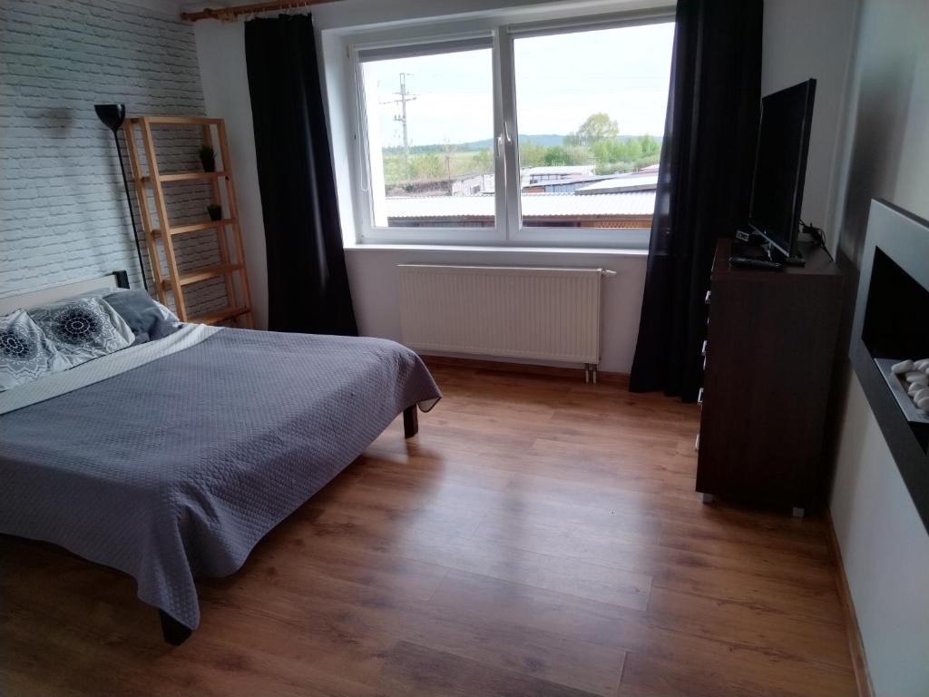 - une chambre avec un lit et une grande fenêtre dans l'établissement Wygodny apartament blisko morza, à Łokciowe
