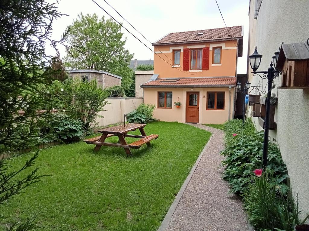 um quintal com uma mesa de piquenique e uma casa em Le gîte embarqué - Géré par Presta-Zen'Services - Barque électrique en supplément em Verdun-sur-Meuse