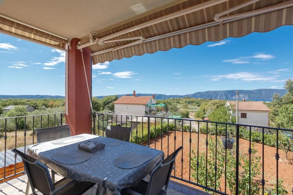 eine Terrasse mit einem Tisch und Stühlen auf dem Balkon in der Unterkunft Family village apartment in Vrh