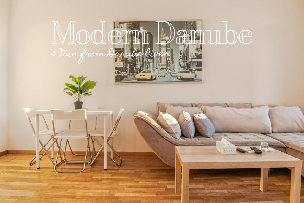Joyful Shared Apt. @ Millenium Tower and Danube River في فيينا: غرفة معيشة مع أريكة وطاولة