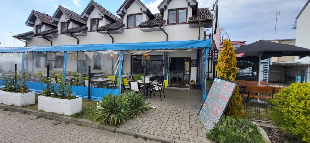 a building with a patio with tables and chairs at Pokoje u Mirka in Dźwirzyno