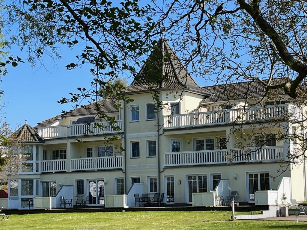 a large white house with a large yard at Schlösschen am Schmachter See in Binz