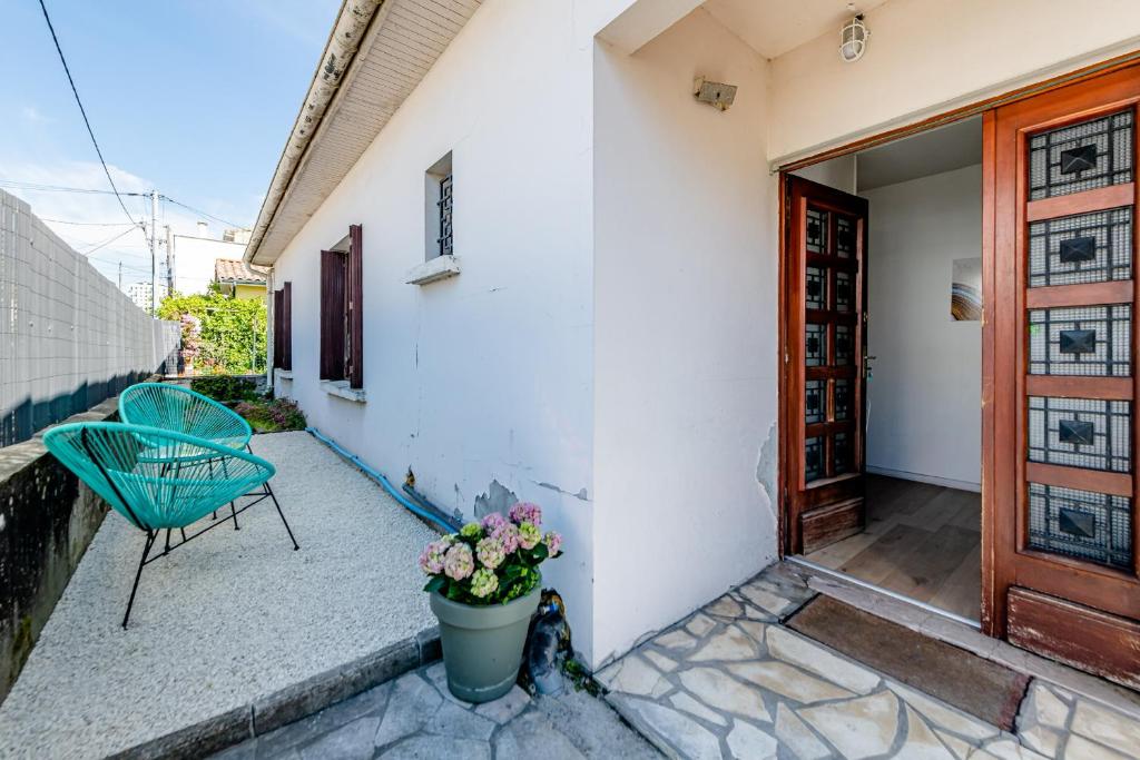 a patio with a green chair and a door at Maison de plain pied avec extérieur in Floirac