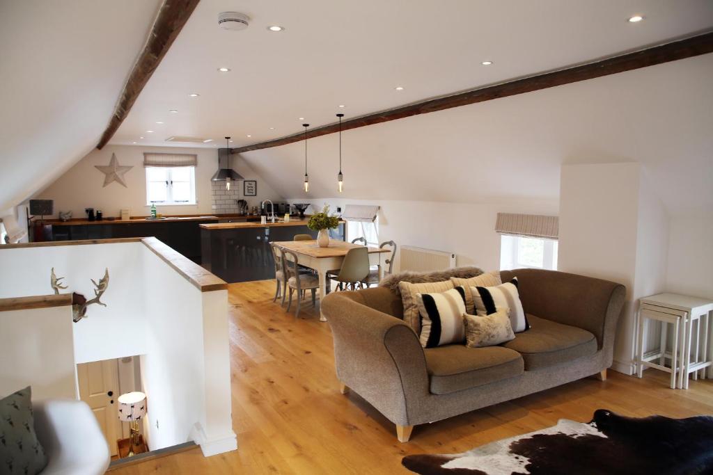 a living room with a couch and a kitchen at The Barn @Bourne Eau House in Bourne