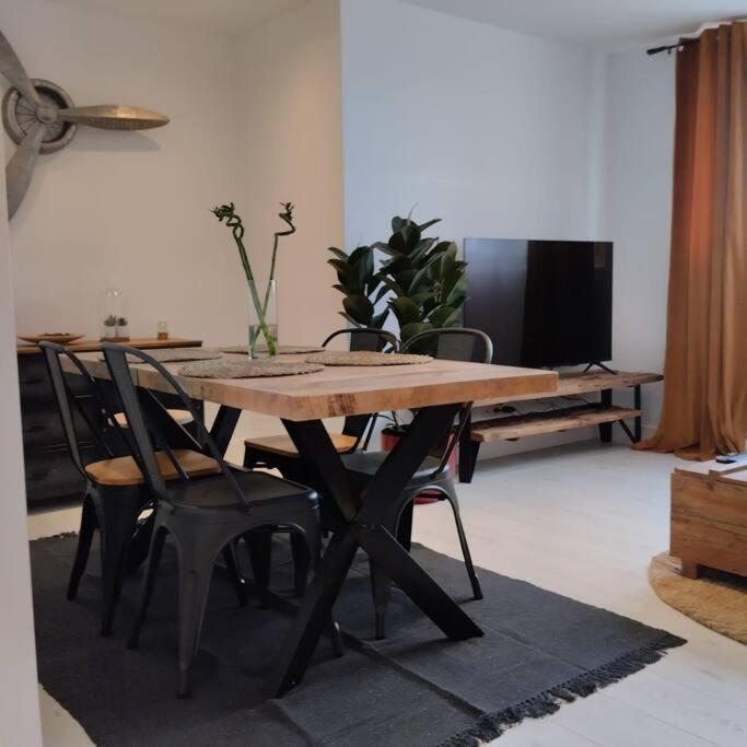 appartement 4 personnes, lumineux et standing في بريست: طاولة وكراسي خشبية في غرفة المعيشة