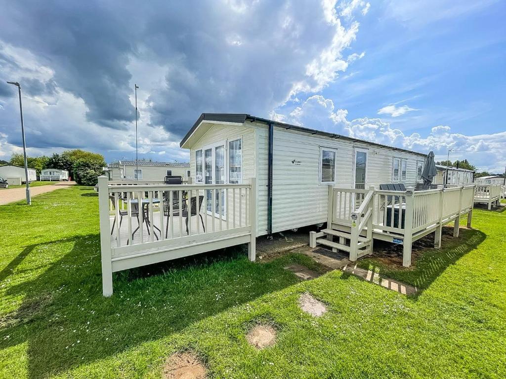 a tiny house with two decks on a lawn at Lovely Caravan Nearby The Beach In Hunstanton, Norfolk Ref 23071c in Hunstanton